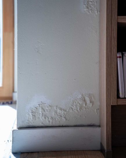 Vocht op de muur, vlak boven de plint. 