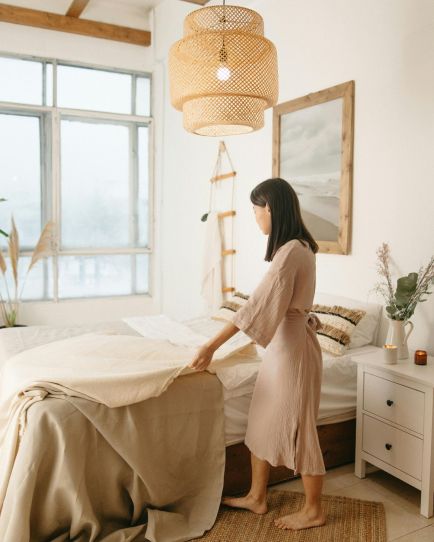 Vrouw maakt bed op in slaapkamer