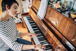 Vrouw speelt piano in haar woonkamer